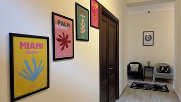 A hallway with framed posters of Miami Beach, Palm Beach, and Capri Beach.