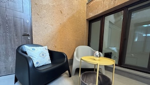 A corner room with a black chair, a small yellow table, and a grey basket. - Velvet Vouge Hostel (Yerevan)