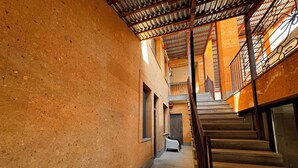 A narrow hallway with a staircase leading to an upper level. The walls are textured and the floor is tiled. - Velvet Vouge Hostel (Yerevan)