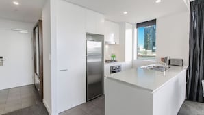 Una cocina moderna con un refrigerador de acero inoxidable, un horno empotrado y una isla grande con un lavamanos.