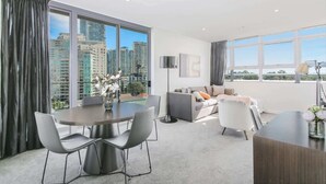 Una sala moderna con comedor, ventanas amplias y vistas a la ciudad.