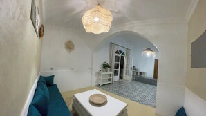 A living room with a sofa, a coffee table, and a hanging light fixture.