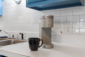 Una cocina moderna con cafetera, pileta y encimera.