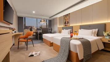 A hotel room with a large bed, a desk, and a television.