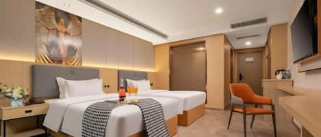 A hotel room with a large bed, a desk, a chair, and a television.