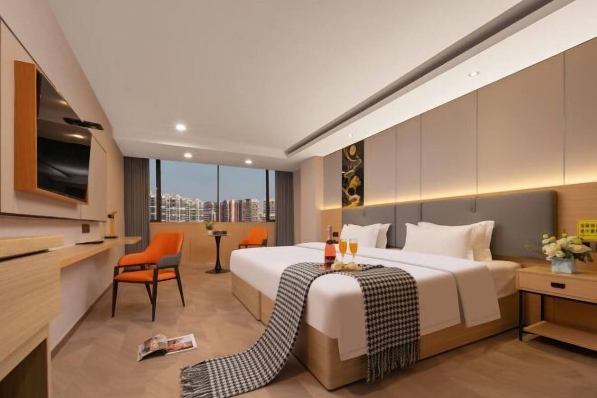 Moderni hotellihuone, jossa on suuri sänky, työpöytä ja tuoli.