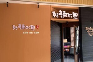 A hotel entrance with a signboard displaying the hotel's name and a partial view of the interior. - Royal Capital International Hotel (Foshan)