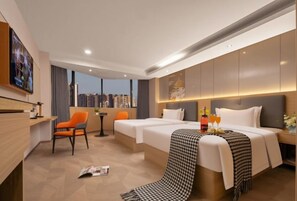 A hotel room with a bed, two chairs, a desk, a TV, and a city view. - Royal Capital International Hotel (Foshan)