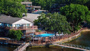 Un hotel con piscina, terraza y vistas al río.