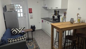 A compact kitchen with white cabinets, a coffee machine, and a small dining area with stools. - Apartamento a 5 minutos de Luxemburgo fully equipped kitchen, lovely terrace (Audun-le-Tiche)