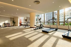 A spacious gym with treadmills, dumbbells, and exercise equipment.