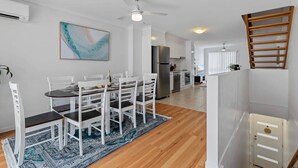 A modern kitchen with white cabinets, a stainless steel refrigerator, and a built-in oven. - Central Redcliffe Coastal Home Walk to Beach (Redcliffe)