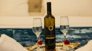 Una botella de vino con dos copas sobre una bandeja, cada una adornada con una rosa.