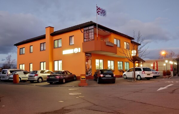 A two-story building with a flat roof, multiple windows, and a flagpole. - Hotel Ganita (Weil am Rhein)