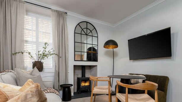 Una sala de estar acogedora con chimenea, un televisor de pantalla plana y una mesa redonda con sillas.