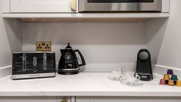 A kitchen with a vintage radio, a coffee maker, and a microwave on the countertop.