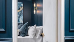 A bedroom with a bed, pillows, a nightstand, and a painting on the wall. - Sapphire Suite The Stirling Residence (Stirling)