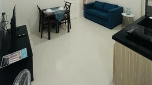 A compact living space with a dining area, a sofa, and a kitchenette. - Charming 1 bedroom apartment with AC, WiFi in lovely Lapu-Lapu City (Lapu-Lapu City)