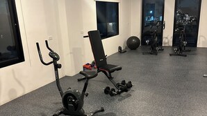A gym with cardio equipment, a bench, and exercise balls. - Charming 1 bedroom apartment with AC, WiFi in lovely Lapu-Lapu City (Lapu-Lapu City)