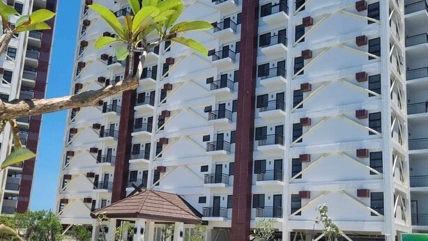 A high-rise building with multiple balconies and a swimming pool in the foreground. - Charming 1 bedroom apartment with AC, WiFi in lovely Lapu-Lapu City (Lapu-Lapu City)
