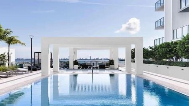 A modern swimming pool with a clear view of the city skyline in the background. - Luxury Penthouse with Water Views and  Massive Private Terrace and Free Parking (Miami)
