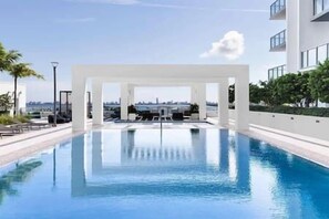 Una piscina moderna con una vista despejada del horizonte de la ciudad al fondo.
