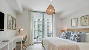 A modern bedroom with a large bed, a desk, and a chair. - Luxury Penthouse with Water Views and  Massive Private Terrace and Free Parking (Miami)