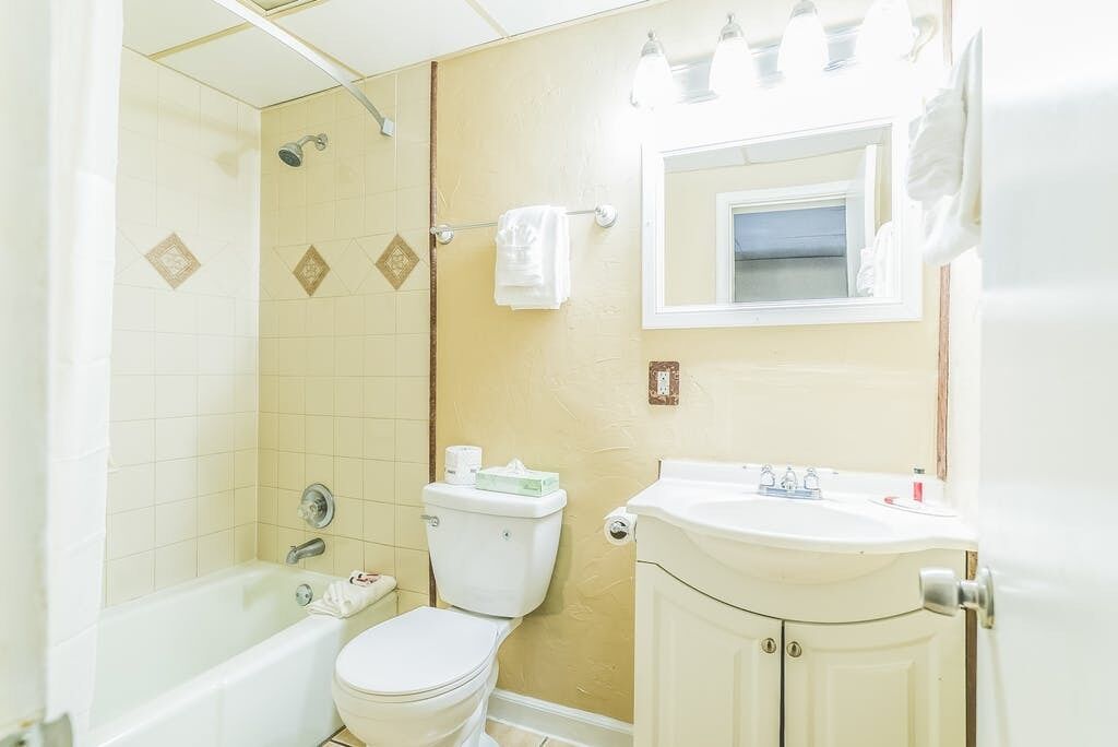 A bathroom with a bathtub, toilet, and sink.