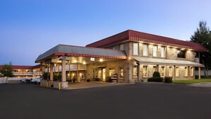 A large, two-story hotel with a red roof and multiple windows. - Montrose Valley Lodge (Montrose)