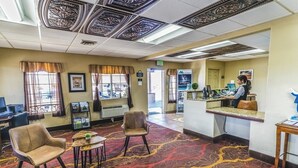 A lobby with a patterned carpet, a reception desk, and a seating area with chairs. - Montrose Valley Lodge (Montrose)