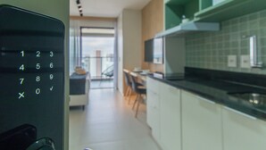 A modern kitchen with white cabinets and a black countertop. - Cozy Refuge Near Allianz Parque Sp-p1504a (São Paulo)