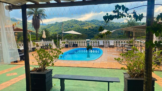 A pool area with a view of a mountainous landscape. - Pousada Encantos da Serra Macacos (Nova Lima)