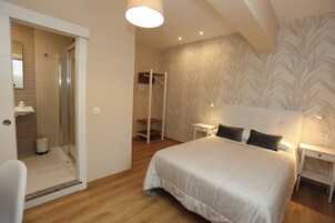 Un dormitorio con una cama grande, un vestidor y una zona de ducha.