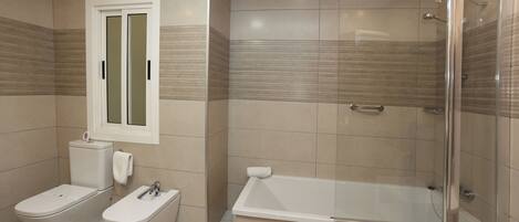 A modern bathroom with a toilet, bidet, and a glass-enclosed shower.