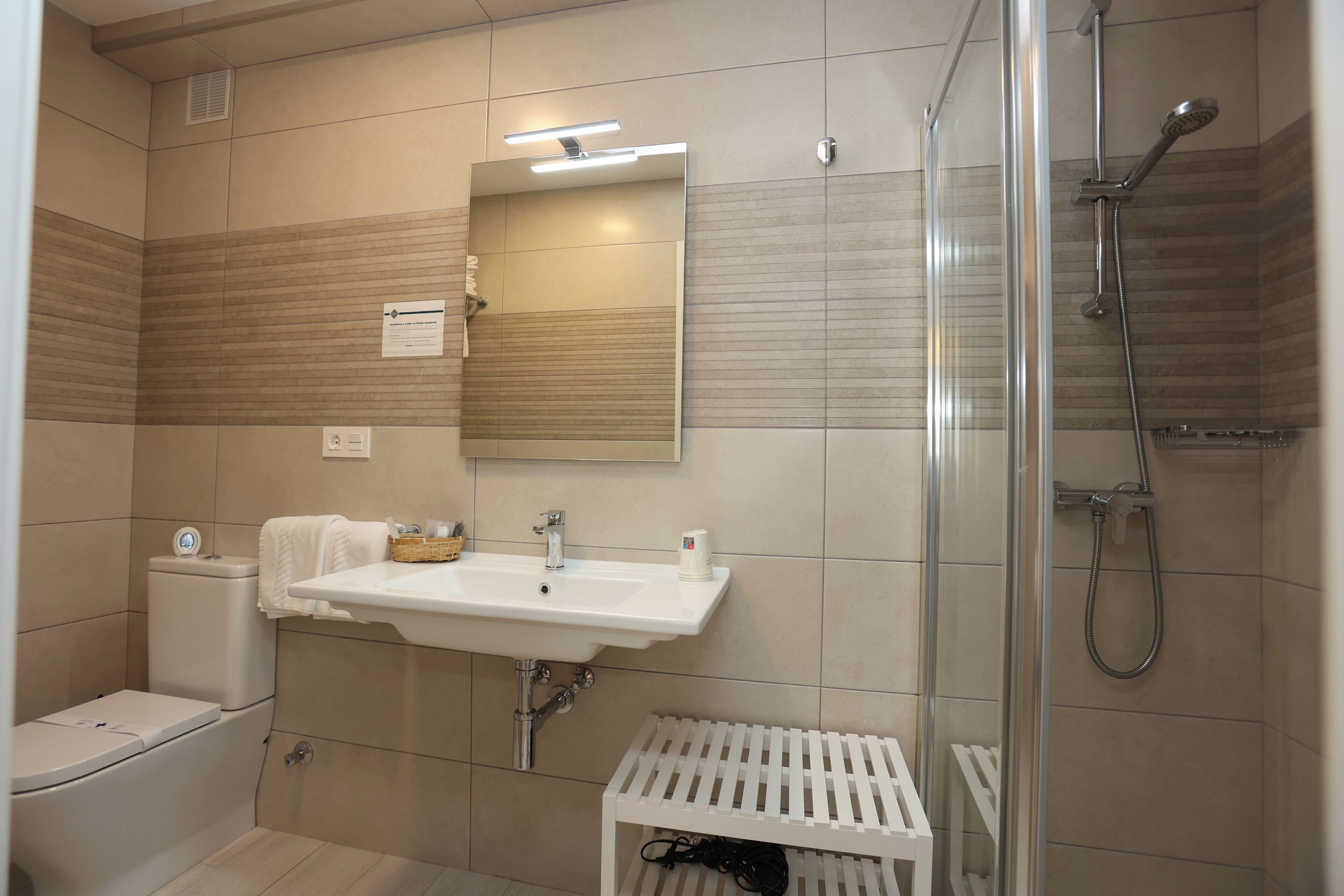 Un baño moderno con inodoro, lavamanos y ducha.