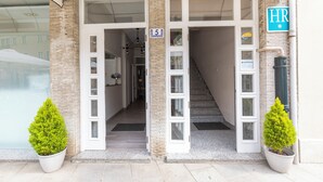 A hotel entrance with a double door, a staircase, and two potted plants. - Hotel Ros Mary (Ribadeo)