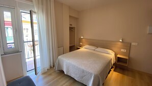 A bedroom with a bed, bedside tables, a wardrobe, and a window with curtains. - Hotel Ros Mary (Ribadeo)