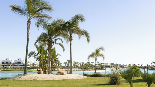 A resort with a pool, palm trees, and a beach view. - Cozy furnished apartment on resort with unique swimming lake (19200)