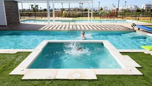 A swimming pool with a diving board and a covered area. - Cozy furnished apartment on resort with unique swimming lake (19200)