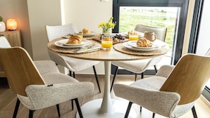 A breakfast table set with croissants, juice, and a vase of flowers. - Cozy furnished apartment on resort with unique swimming lake (19200)