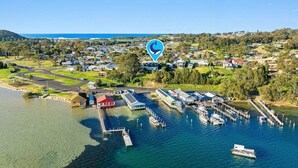 An aerial view of a marina with docks and boats, surrounded by residential buildings and greenery.