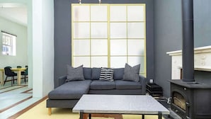 A modern living room with a sectional sofa, a coffee table, and a fireplace. - Funky Pet Friendly, 2-bedroom Escape, Bo-kaap (Cape Town)