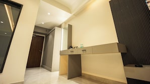 A modern bathroom with a large mirror, a vanity with drawers, and a dark textured wall. - Hotel Shankar Palace Beawar (Beawar)