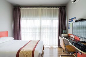 A hotel room with a bed, a desk, a chair, and a window with curtains. - Jinqilin Hotel (Shanghai)