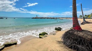 Ranta lähistöllä, aurinkotuoleja, rantapyyhkeitä