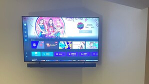 A flat-screen TV mounted on a wall displaying a streaming service interface with various content categories. - Wisc Dells Romantic Getaway for two (Baraboo)