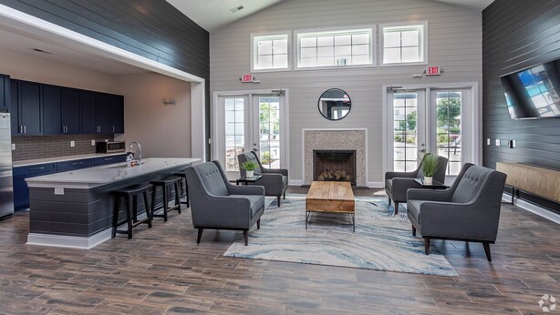 A spacious living area with a large island, dark wood flooring, and modern furniture. - Landing Myrtle Beach (Socastee)