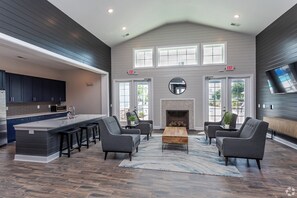 A spacious living area with a large island, dark wood flooring, and modern furniture. - Landing Myrtle Beach (Socastee)