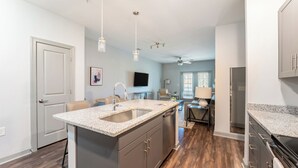 A modern kitchen with granite countertops, stainless steel appliances, and a central island. - Landing Myrtle Beach (Socastee)