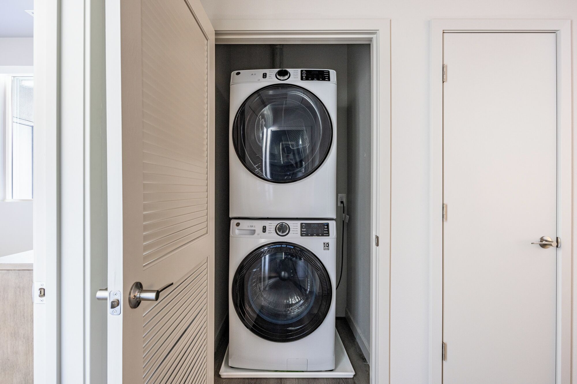A laundry room with two stacked front-loading washing machines.